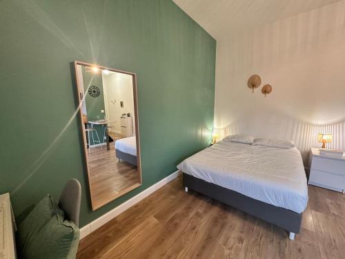 a bedroom with a bed and a large mirror at Le petit Verdier Mosellan - Thionville - 2P in Thionville