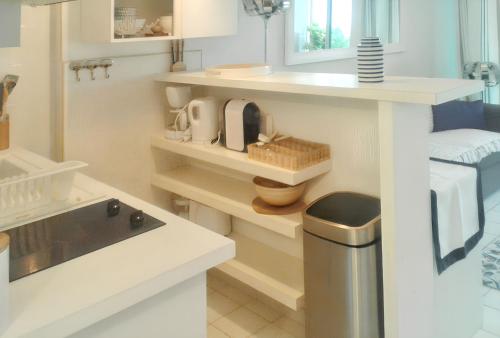 a small white kitchen with a sink and a counter at Studio Vue Mer à Collioure - 27 m² - Parking Inclus in Collioure