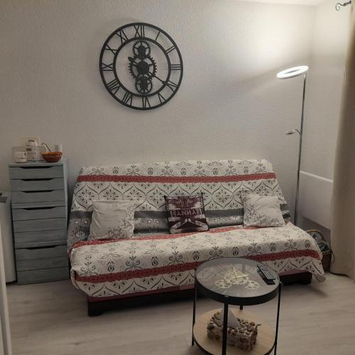 un salon avec un canapé et une horloge au mur dans l'établissement Vue sur Mer, à Saint Pierre La Mer