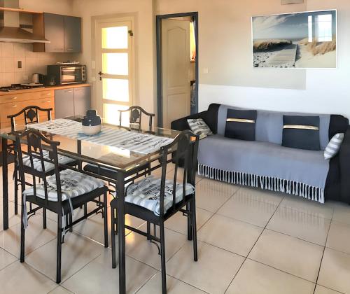 un salon avec une table, des chaises et un canapé dans l'établissement Appartement lumineux à Collioure avec terrasse et vue sur mer, à Collioure