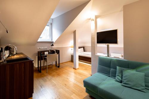 a living room with a green couch and a bedroom at BoardingWorld Heidelberg in Heidelberg