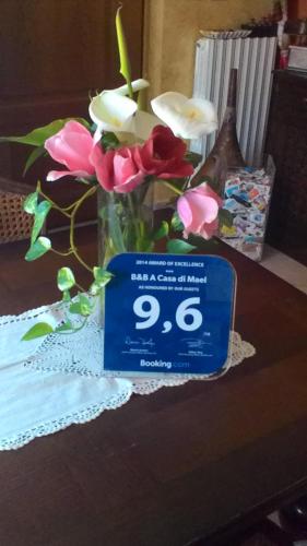 a vase with flowers and a sign on a table at B&B A Casa di Mael in San Costanzo