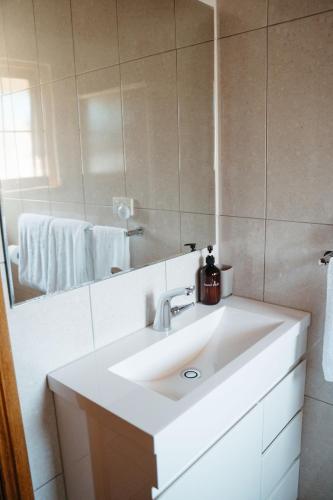 a bathroom with a white sink and a mirror at Langmeil Cottages in Tanunda