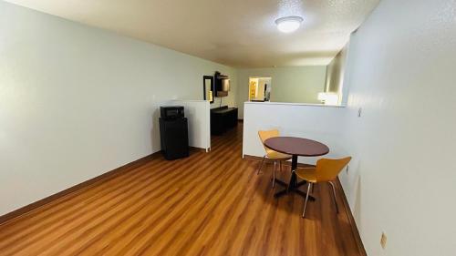 a small room with a table and chairs and a refrigerator at Super 7 Inn Tupelo in Tupelo