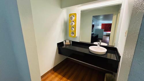 a bathroom with a sink and a mirror at Super 7 Inn Tupelo in Tupelo