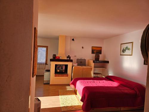 a bedroom with a red bed and a fireplace at La Casa Del Lupo in Serina