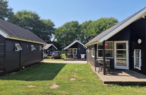 a house with a porch and a house with a yard at First Camp Ajstrup Strand in Malling