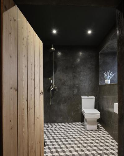 a bathroom with a toilet and a black wall at The West Wing in Barnstaple