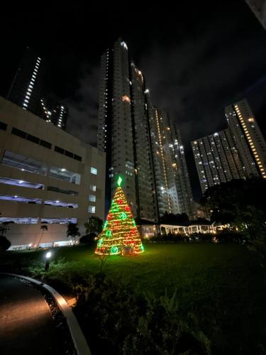a christmas tree in front of a city at night at ALG's Place Quezon City in Manila