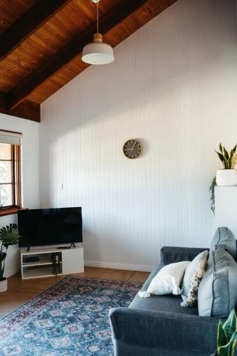 a living room with a blue couch and a tv at Langmeil Cottages in Tanunda