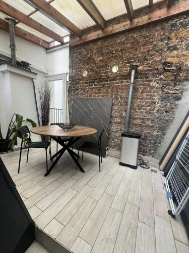 une pièce avec une table et des chaises et un mur de briques dans l'établissement bridgestreet ST GERMAIN, à Paris