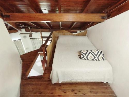 a bed in a small room with a wooden ceiling at Puerto Sosiego in Gualeguaychú