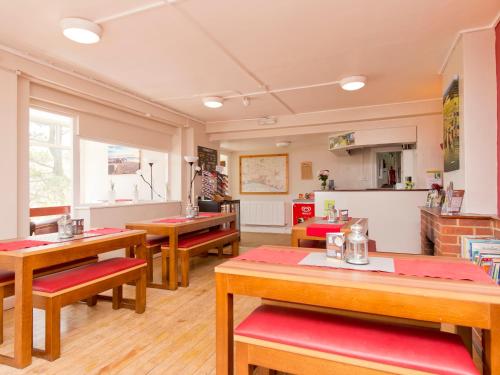 a dining room with wooden tables and benches at YHA Truleigh Hill in Shoreham-by-Sea