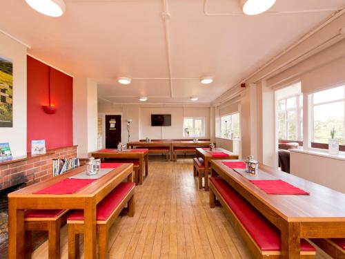 a dining room with wooden tables and benches at YHA Truleigh Hill in Shoreham-by-Sea