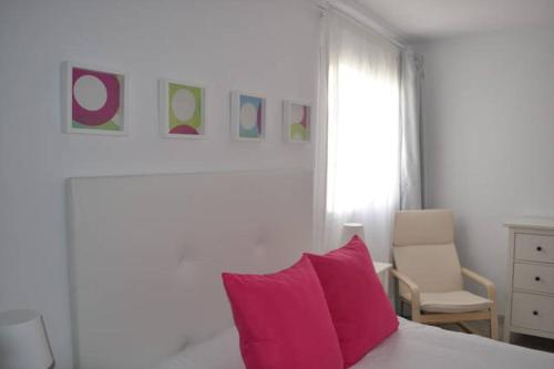 ein Schlafzimmer mit einem rosa Kissen und einem Stuhl in der Unterkunft Elena Beach House Lanzarote in Playa Honda