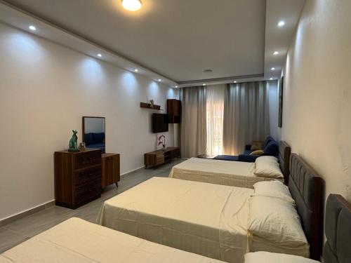 a hotel room with three beds and a mirror at Azur Dream by the Sea in Hurghada