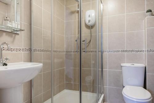 Un baño con ducha, inodoro y lavabo. en Life of Riley, en St Ives
