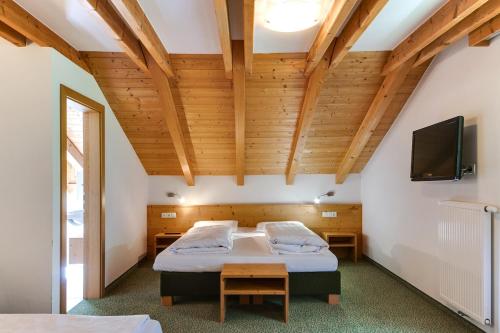 a bedroom with two beds and a flat screen tv at Smy Koflerhof Wellness & Spa Dolomiti in Rasun di Sopra