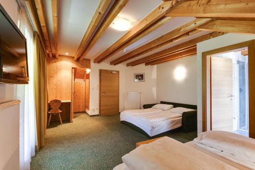 a hotel room with two beds and a window at Smy Koflerhof Wellness & Spa Dolomiti in Rasun di Sopra