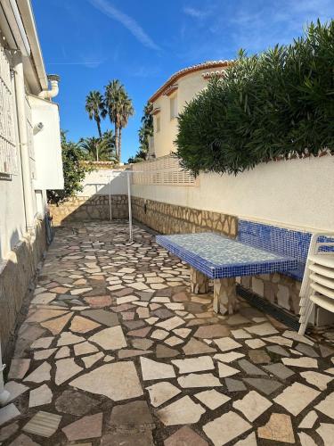 a bench sitting on a stone walkway next to a building at Chalet con piscina privada in El Verger