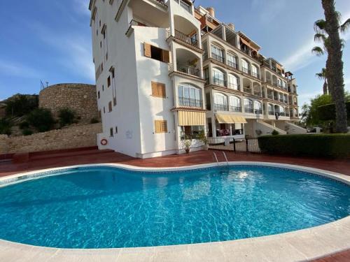 a building with a swimming pool in front of a building at Appartement 3 chambres, piscine et vue mer in Santa Pola