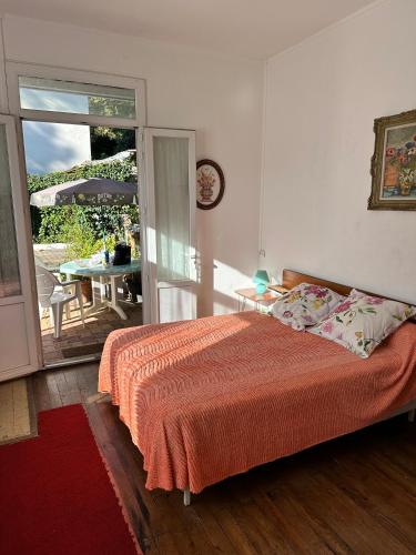 une chambre avec un lit et un balcon avec une table dans l'établissement 2 chambres Arcachon & Moulleau accès Plage - Salle de bain & coin petit déjeuner, à Arcachon