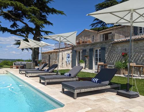 - une piscine avec des chaises longues et un parasol dans l'établissement The Old Presbytery, à Saint-André-et-Appelles