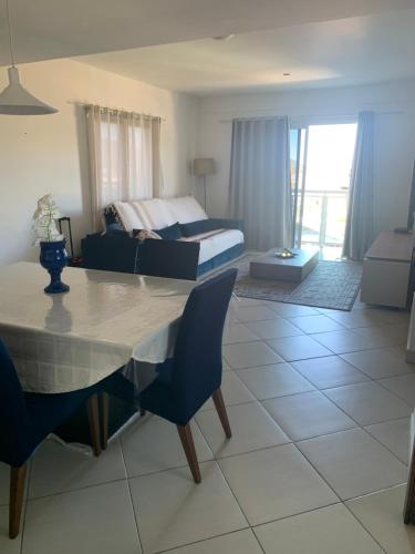 ein Wohnzimmer mit einem Bett und einem Tisch und Stühlen in der Unterkunft Ap praia dos anjos com vista in Arraial do Cabo