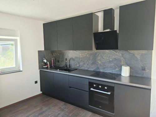 a kitchen with black cabinets and a counter top at Villa AS MOON with pool in Split