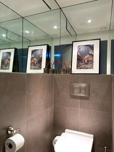 une salle de bain avec toilettes et miroir dans l'établissement L'appartement des Archives, à Paris