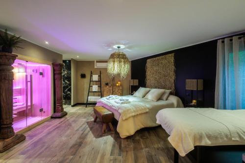 a bedroom with two beds and pink lighting at pampa-chambre-hote et spa in Warhem