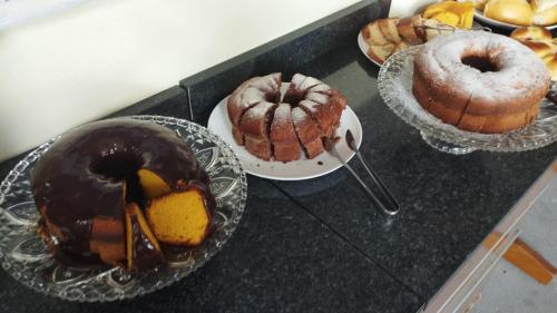 - un bouquet de différents types de gâteaux et de pâtisseries sur un comptoir dans l'établissement Pousada São Benedito, à Cachoeira Paulista