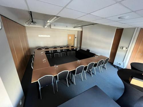 a conference room with a long table and chairs at Quality Silesian Hotel in Katowice