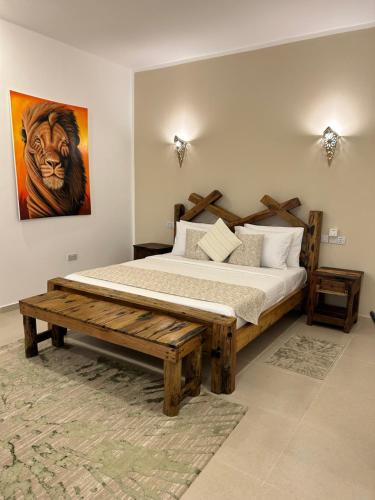 a bedroom with a wooden bed and a painting of a tiger at M&M Villas Zanzibar in Kidoti