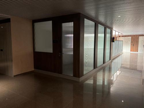 a room with a bed with glass doors in it at Hotel Four Point Corner in Pāli