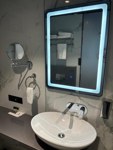a bathroom with a white sink and a mirror at Hotel Four Point Corner in Pāli