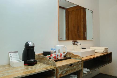 a bathroom counter with a sink and a mirror at The Setumbu Experience, ARTOTEL Curated in Kembanglimus