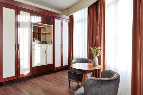 a room with a table and chairs and a kitchen at De L’Europe Amsterdam – The Leading Hotels of the World in Amsterdam