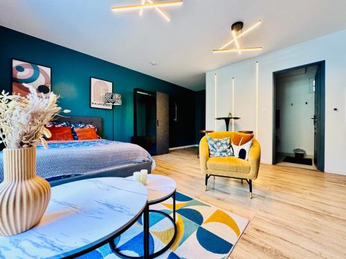 a bedroom with a king sized bed and a yellow chair at Studio-St Pierre centre proche toutes commodités in Saint-Pierre