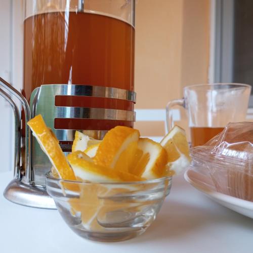 a glass bowl filled with orange slices next to a juicer at B&B Villa Maurizio in Tskaltubo