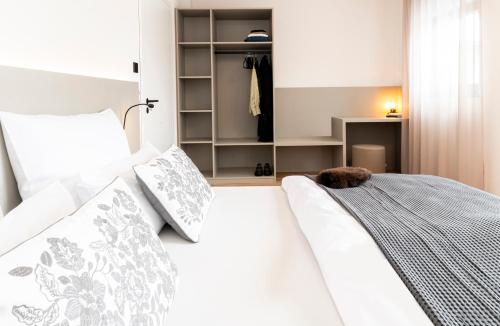 a bedroom with a white bed with a stuffed animal on it at AmRain Ferienwohnungen in Altusried
