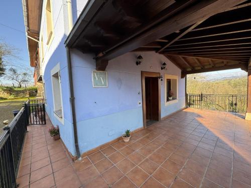 a patio of a house with a porch at La Casa Azul 1 en Asturias in Nava