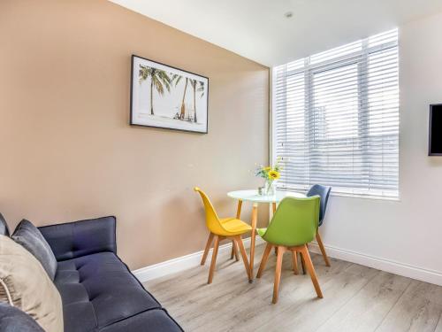a living room with a couch and a table and chairs at Contemporary Modern Studio in Portsmouth