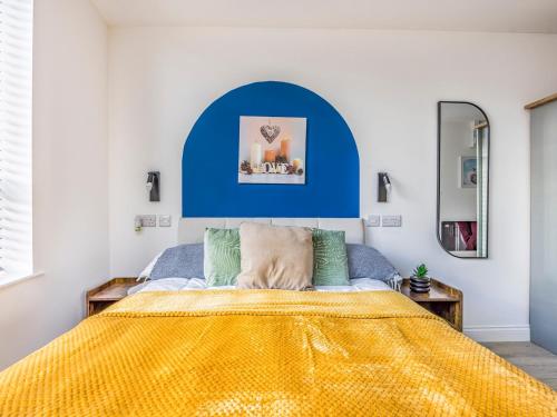 a bedroom with a bed with a yellow blanket at Contemporary Modern Studio in Portsmouth