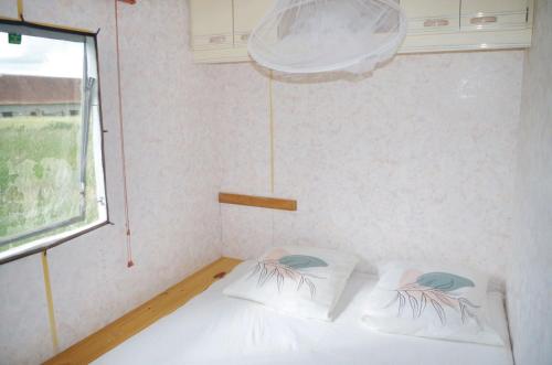 une chambre avec un lit blanc et une fenêtre dans l'établissement Bungalow charmant à Pierrefitte-sur-Loire + jardin et BBQ, à Pierrefitte-sur-Loire