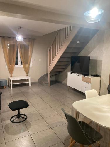 un soggiorno con una scala, un tavolo e delle sedie di Maison tout confort 6 personnes wifi parking a Colomiers