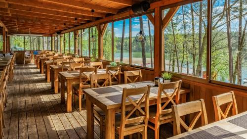 鲁恰内尼达Ośrodek Wypoczynek Wodnik的餐厅里有桌椅和窗户。