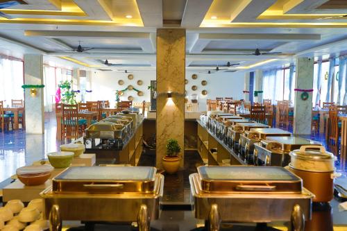 a restaurant with a row of tables and chairs at The Grand Retreat - Chikmagalur in Chikmagalūr