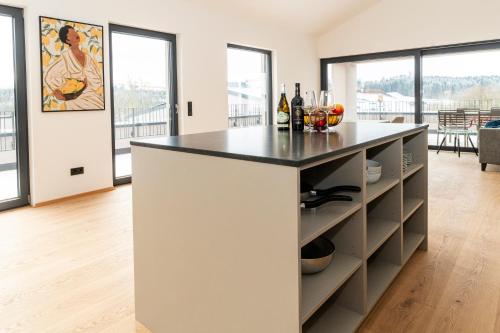 a kitchen with a island with a black counter top at AmRain Ferienwohnungen in Altusried