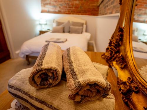 a bathroom with towels on a table next to a mirror at Hood Lane Farm - The Parlour - Self Catering Ground Floor Apartment in Arley
